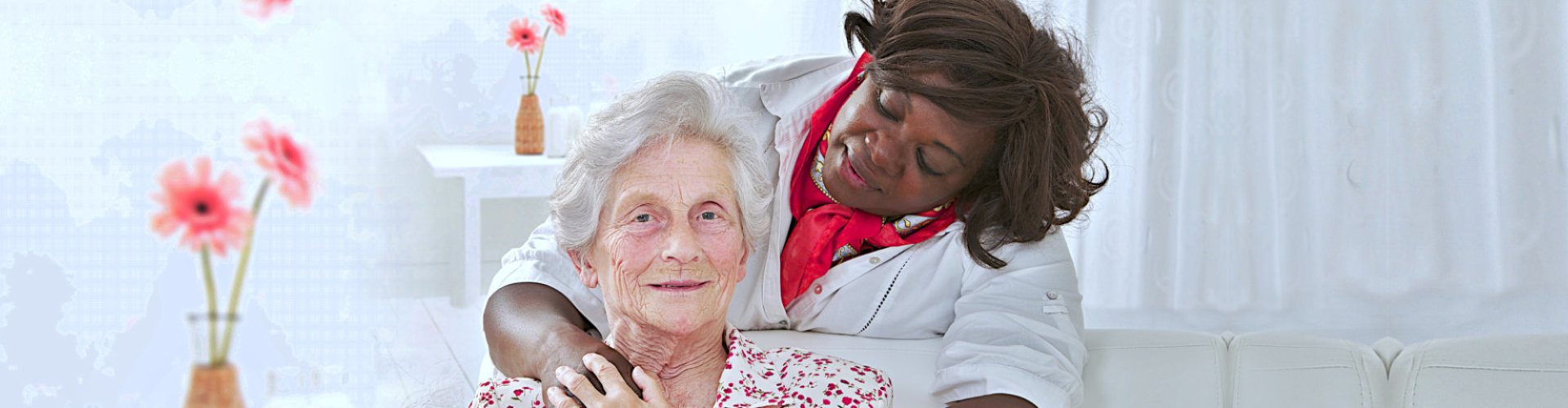 caregiver hugs senior woman smiling
