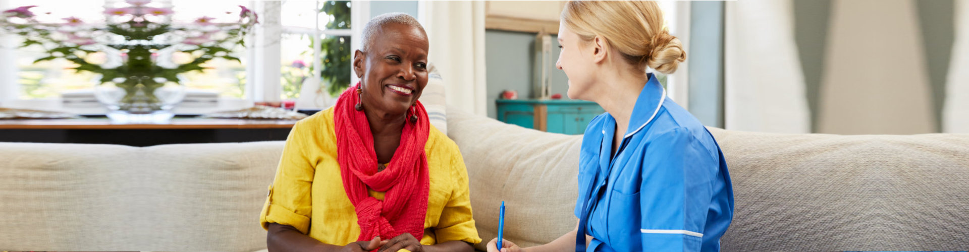 caregiver having a conversation with the senior woman smiling